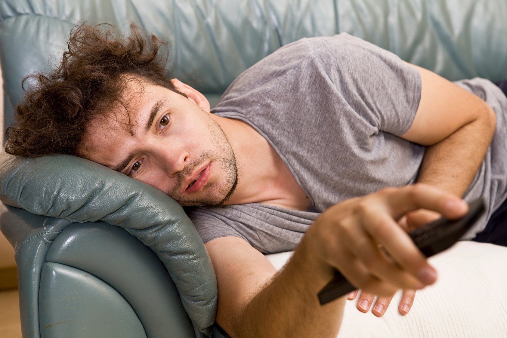 Lazy man with the remote on the couch